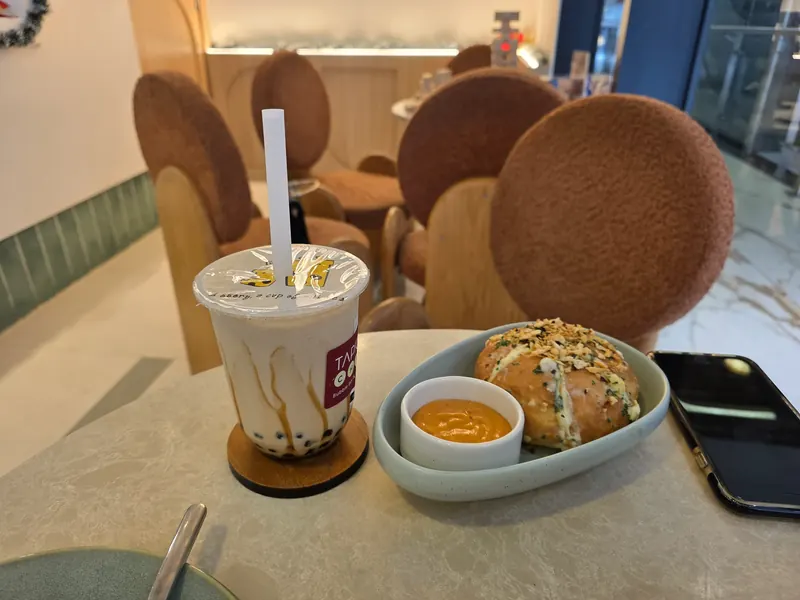 A milk tea and garlic bun on a table at Jubilee Walk