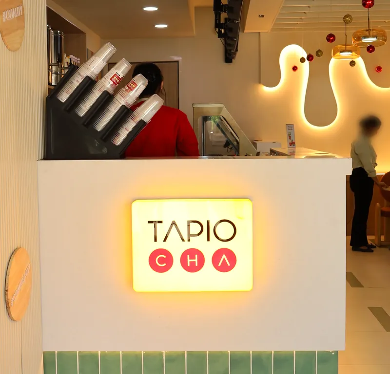The lit Tapiocha sign over the Jubilee Walk counter