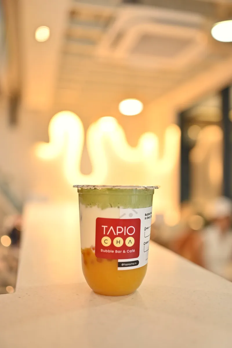 Mango matcha on the counter under the neon